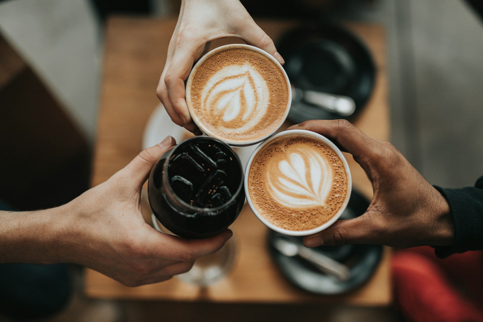 Two people raising coffee cups together